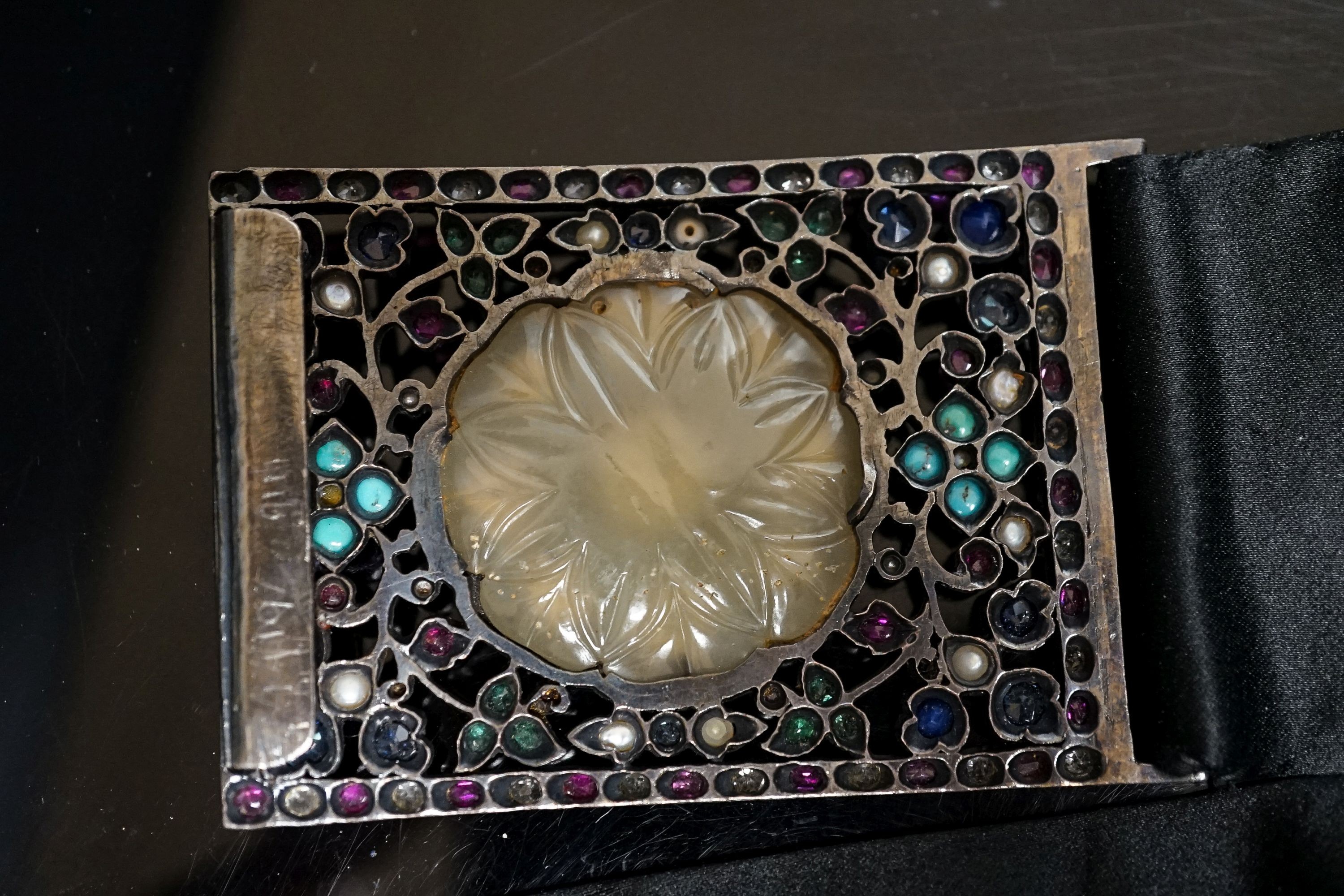 An Indian multi gem set belt buckle, mounted on a black sash belt, buckle 8cm.